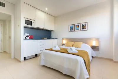 a bedroom with a large bed with towels on it at Apartoyou - Estudio del Sol in El Puerto de Santa María