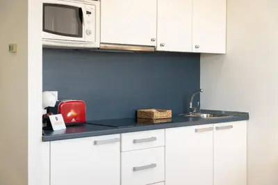 a kitchen counter with a microwave and a sink at Apartoyou - Estudio del Sol in El Puerto de Santa María