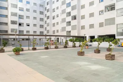 a courtyard in front of a building with potted trees at Apartoyou - Estudio del Sol in El Puerto de Santa María