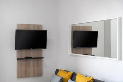 a living room with a tv and a mirror at Apartoyou - Estudio del Sol in El Puerto de Santa María