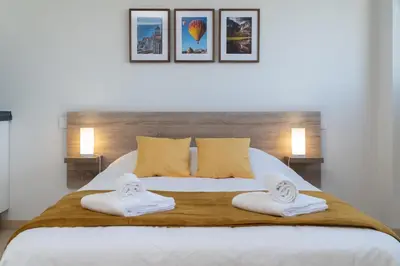 a bedroom with a large white bed with two towels at Apartoyou - Estudio del Sol in El Puerto de Santa María