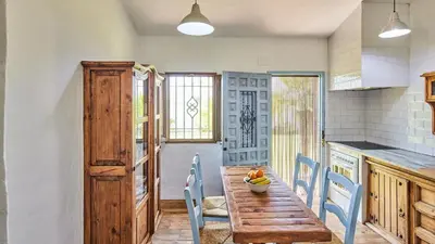 a kitchen with a wooden table and blue chairs at Casa García Camacho Conil de la Frontera by Ruralidays in Conil de la Frontera