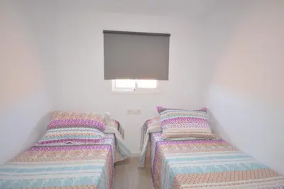 two twin beds in a room with white walls at Casas Buenavista in Conil de la Frontera