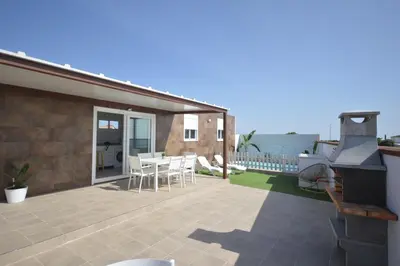 a patio with a grill and a table and chairs at Casas Buenavista in Conil de la Frontera