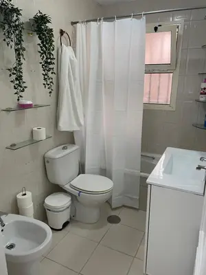 a white bathroom with a toilet and a sink at Bonito y ubicación inmejorable in Sanlúcar de Barrameda