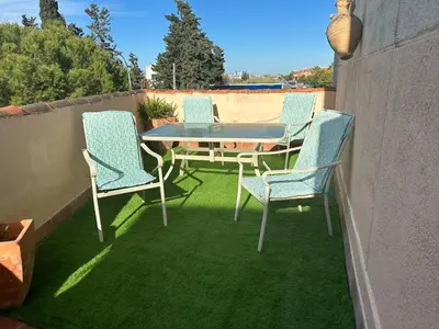 a patio with a table and chairs on the grass at Bonito y ubicación inmejorable in Sanlúcar de Barrameda