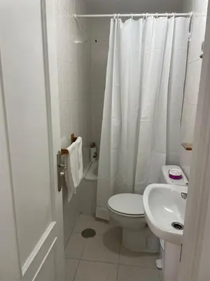 a white bathroom with a toilet and a sink at Bonito y ubicación inmejorable in Sanlúcar de Barrameda