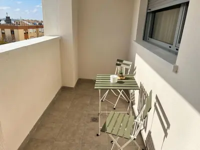 a table and chairs on a balcony with a window at Jardines del Porvenir 2 in Puerto Real