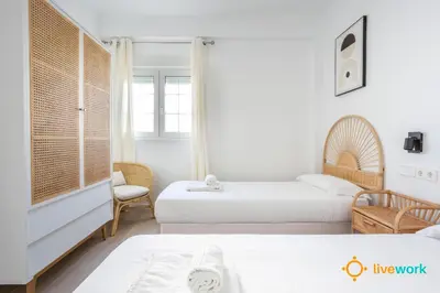 a hotel room with two beds and a chair at Terrace Home by LiveWork in Cádiz