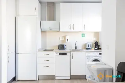 a kitchen with white cabinets and a washer and dryer at Terrace Home by LiveWork in Cádiz