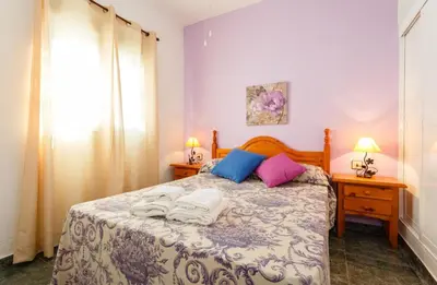 a bedroom with a bed with two night stands and two lamps at Apartamento Casa Postas II in Conil de la Frontera
