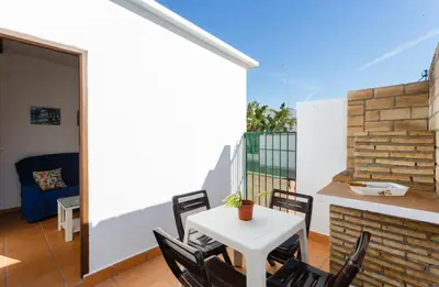 a patio with a white table and chairs on a balcony at Apartamento Casa Postas II in Conil de la Frontera