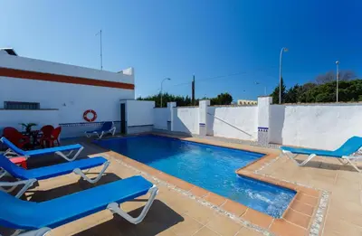 a swimming pool with blue lounge chairs on a roof at Apartamento Casa Postas III in Conil de la Frontera