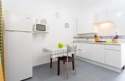 a white kitchen with a table and a microwave at Apartamento Casa Postas III in Conil de la Frontera