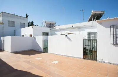 a white building with a gate on the side of it at Apartamento Casa Postas III in Conil de la Frontera