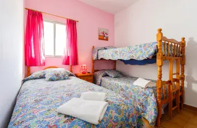 a bedroom with two beds and a bunk bed at Apartamento Casa Postas I in Conil de la Frontera