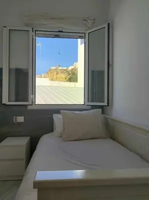 a bed in a room with a large window at Casa Mirador del Puente in Arcos de la Frontera