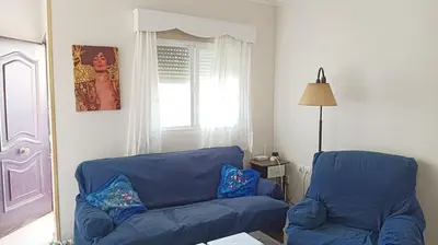 a living room with a blue couch and a window at Casa de campo con piscina in Chiclana de la Frontera