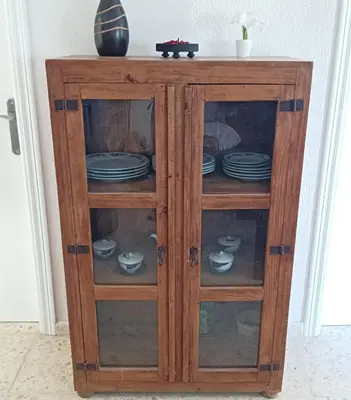 a wooden cabinet with plates and dishes in it at Casa de campo con piscina in Chiclana de la Frontera