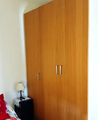 a large wooden cabinet in a bedroom with a bed at Casa de campo con piscina in Chiclana de la Frontera