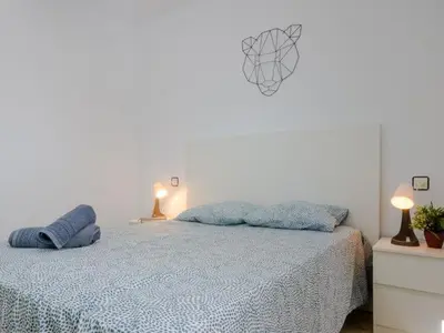 a bedroom with a bed with two blue pillows on it at Las Torres 197 in Novo Sancti Petri