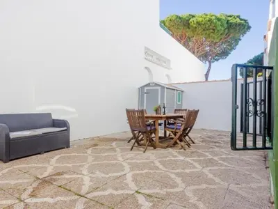a room with a table and chairs and a couch at Las Torres 197 in Novo Sancti Petri