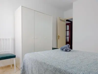 a bedroom with a bed with a blue towel on it at Las Torres 197 in Novo Sancti Petri
