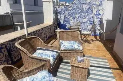 a balcony with two wicker chairs and a table at Precioso Ático en el Centro Histórico de Cádiz in Cádiz