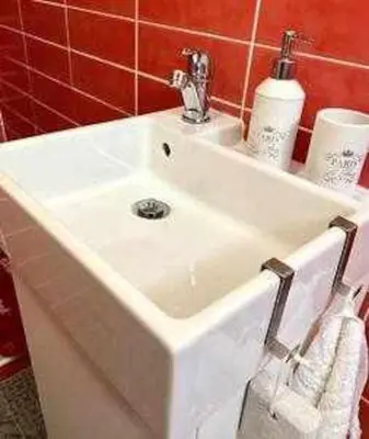 a white sink in a bathroom with red tiles at Precioso Ático en el Centro Histórico de Cádiz in Cádiz