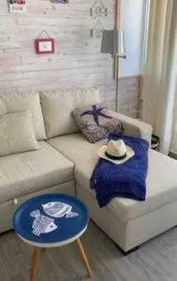 a living room with a couch and a blue stool at Precioso Ático en el Centro Histórico de Cádiz in Cádiz
