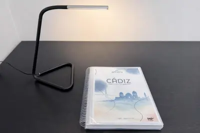 a book sitting on a table next to a lamp at Apartamento Amaro Cádiz - Playa Victoria in Cádiz