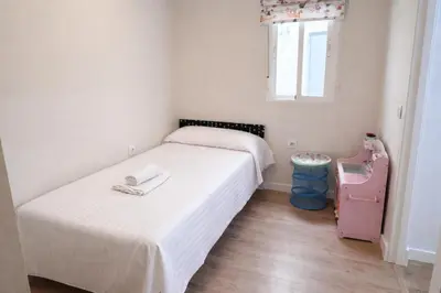 a small bedroom with two beds and a small table at Apartamento Amaro Cádiz - Playa Victoria in Cádiz