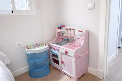 a pink play kitchen in a corner of a room at Apartamento Amaro Cádiz - Playa Victoria in Cádiz