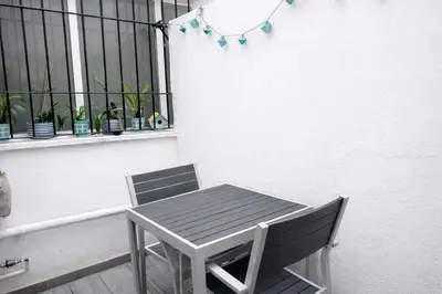 a table and chair on a balcony with a window at Apartamento Amaro Cádiz - Playa Victoria in Cádiz