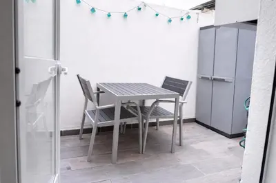a table and chairs in a room with a refrigerator at Apartamento Amaro Cádiz - Playa Victoria in Cádiz
