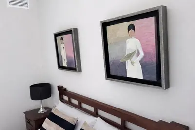 a painting of a woman on a wall next to a bed at Apartamento Amaro Cádiz - Playa Victoria in Cádiz
