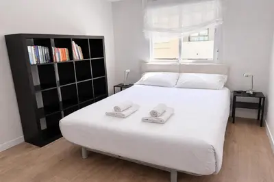 a bedroom with a white bed with two slippers on it at Apartamento Amaro Cádiz - Playa Victoria in Cádiz