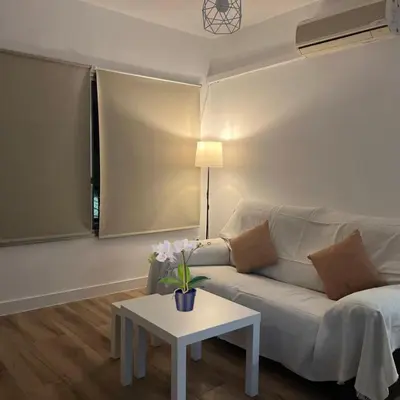 a living room with a white couch and a table at Piso cercano al recinto ferial in Jerez de la Frontera