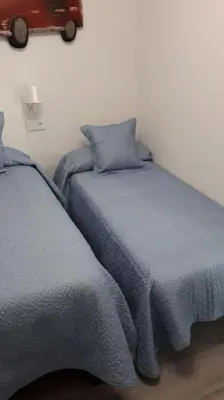 two beds in a room with a car on the wall at Sanlucar-Centro in Sanlúcar de Barrameda