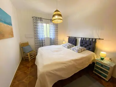 a bedroom with a large white bed and a lamp at Casa Isabela in Chiclana de la Frontera