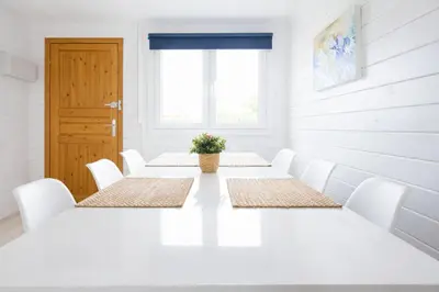 a white room with a table and white chairs at PuraVidaChiclana in Chiclana de la Frontera