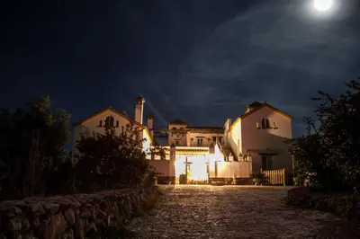 a house at night with the moon in the sky at El Fogón del Duende in Arcos de la Frontera