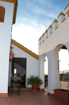 a white house with a patio with a table at El Fogón del Duende in Arcos de la Frontera