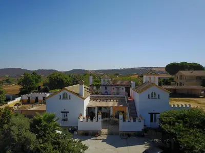 a large white house with a porch at El Fogón del Duende in Arcos de la Frontera