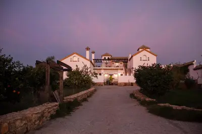 a large white house with a road in front of it at El Fogón del Duende in Arcos de la Frontera