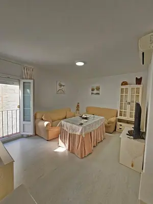 a living room with a table and a couch at Apartamento Centro Cabildo in Sanlúcar de Barrameda
