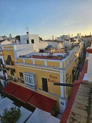a yellow building with a sign on top of it at Apartamento Centro Cabildo in Sanlúcar de Barrameda