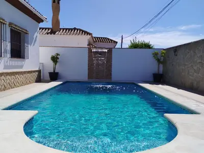 a swimming pool in the backyard of a house at Casa Ramos in Conil de la Frontera