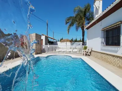 a fountain in the middle of a swimming pool at Casa Ramos in Conil de la Frontera