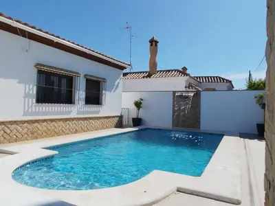 a villa with a swimming pool and a house at Casa Ramos in Conil de la Frontera